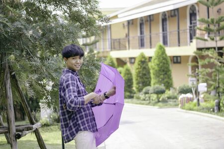 Asian man raise an umbrella to protect sun, hot weather, vintage tone
