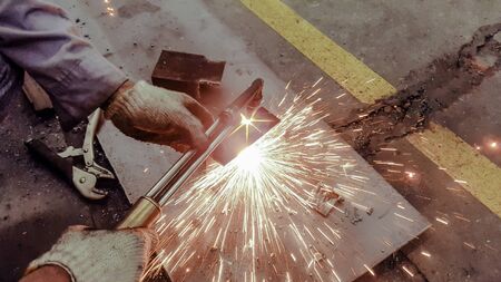 Cutting metal plate by gas flame, Worker are welding metal work in factoryの写真素材