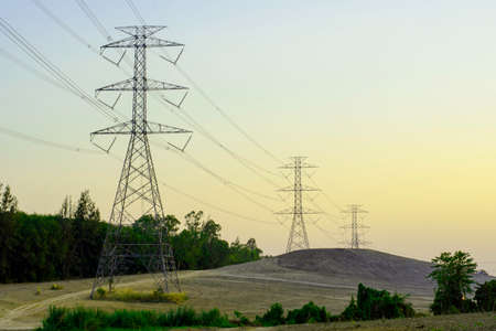 Electricity pole with silhouette sunset sky, Electricity pylon with shadow of tree in dawn time, Electricity power transmission line on sunset with copy space, Electricity pylon on orange skyの写真素材