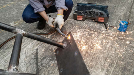 Cutting metal plate by gas flame, Worker are welding metal work in factory