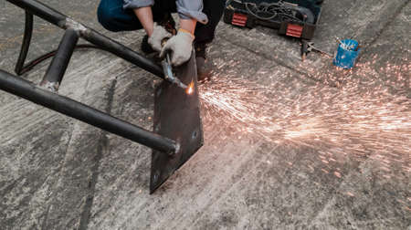 Cutting metal plate by gas flame, Worker are welding metal work in factory