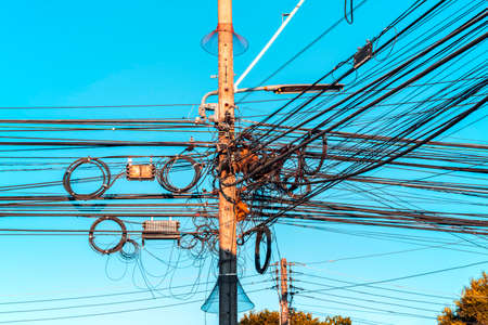 Tangled wire on electricity pole in the city, Busy electricity wire on pillarの写真素材