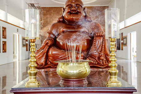 Visit the biggest temple in Batam island, Indonesia - Nov 29, 2018,  The golden incense pot in front of the marble laughing Buddha statues the Maha Vihara Duta Maitreya Temple in Batam Islanのeditorial素材
