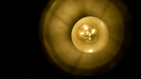 Close up incandescent lamp shining, Yellow light of lamp hang on ceiling
