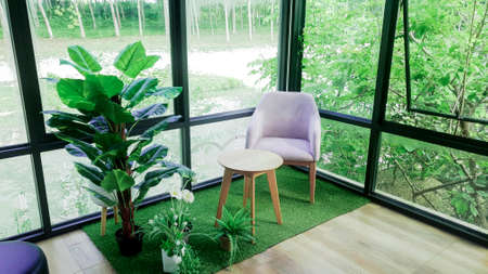 Modern interior chair and table in cafe restaurent with green nature, Quiet and chill atmosphere in the morning, Glass windows room look out to see nature view.の写真素材