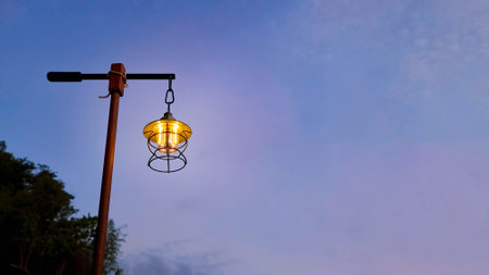Lantern light camping in the evening, Antique lamp hang on wooden stand in the forest at night...