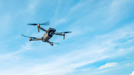 Drone machine with blue sky background for commercial marketing. Drone services for land and environmental assessment, providing reliable aerial insightsの写真素材