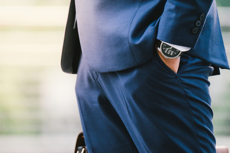 business man hand in pocket with wrist watch in a business suit close upの写真素材