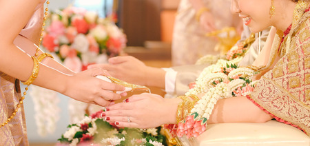 Hands pouring blessing water into bride's bands, Thai weddingの写真素材