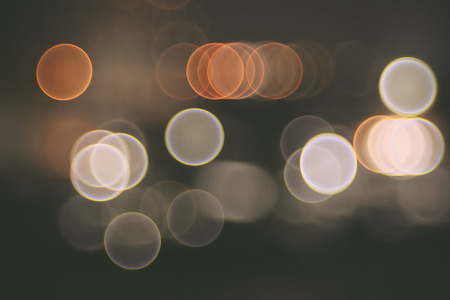 Lights blurred bokeh background from city in the night. In vintage or retro color tonedの写真素材