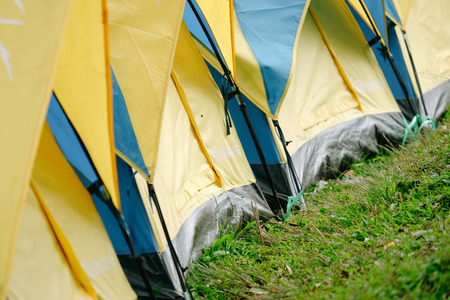 Yellow and blue tourist tent on the green grass in Thailandの写真素材