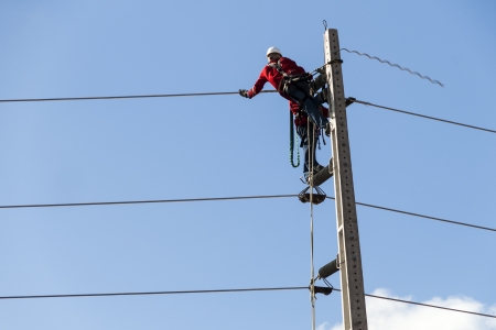 Electricians working on a pylon of the public power line. Fortaleza, Brazil