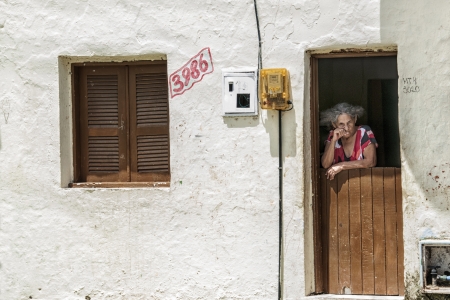 Elderly woman on the front door  Community of the city center that will be expropriated and removed because of the World Cup 2014, Fortaleza, Brazilのeditorial素材