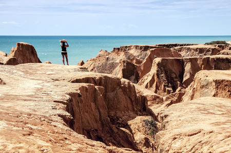 FORTALEZA, CEARA STATE, BRAZIL - JUN 19: Young woman on the rocky beach of Morro Branco on June 19 2011, in Fortaleza, Ceara State, Brazilのeditorial素材