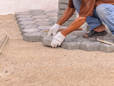 mason worker making pavement with stone blocks の写真素材