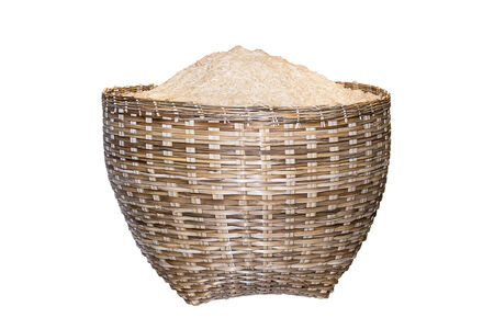 Uncooked white rice in bamboo basket on white.の写真素材