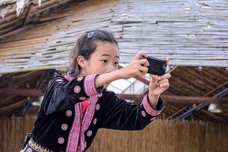 CHIANG MAI, THAILAND - OCTOBER 18 : Unidentified Hmong children take pictures by mobile phone on October 18, 2014, Chiang Mai,Thailand. Hmong are an ethnic group spread in Thailand.のeditorial素材
