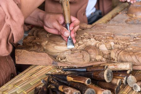 Hands of the craftsman wooden carving a bas-relief.の写真素材