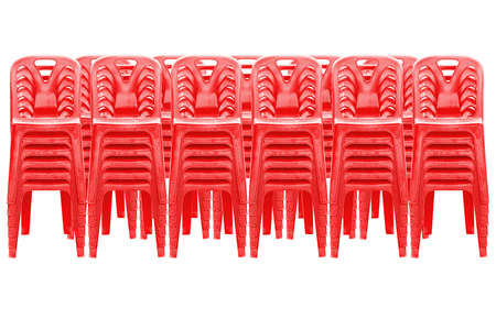 Stack of red plastic chairs on whiteの写真素材