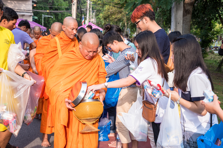 CHIANG MAI, THAILAND - OCTOBER 28, 2015: People offer food to monks in Devo tradition on October 28, 2015 in Chiang mai, Thailand. Tak Bat Devo is the tradition to recall when the Buddha returned from visit to his mother in Heaven.のeditorial素材