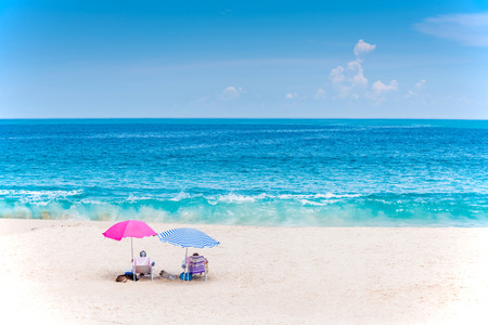 Beach chairs with umbrella on the beach on summer day. Blue sky and sea in the background.の写真素材
