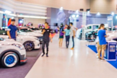 Abstract people walking in motor show blurred defocusing background. Concept of business social gathering for meeting exchange.の写真素材