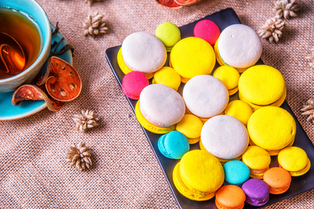 Colorful french macarons with cup of bael tea on table. Macaron is popular dessert for served with tea or coffeeの写真素材