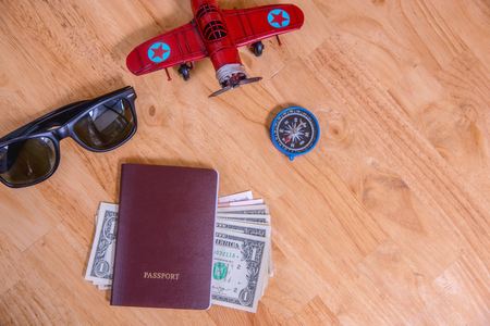 Travel concept,passport, money, compass, plane, sunglasses on wooden table.Traveler's accessories, Top view の写真素材
