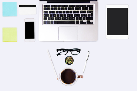 Business working at an office, Modern white office desk table with laptop computer, smartphone, notepaper and cup of coffee. Top view with copy space, flat lay.の写真素材