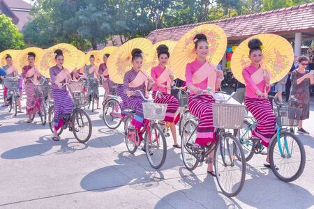 CHIANG MAI, THAILAND - JANUARY 17, 2020 : 37th anniversary Borsang umbrella festival, Unidentified peoples in traditional costume ride a bicycle during the annual Umbrella festival at San Kampaeng.のeditorial素材