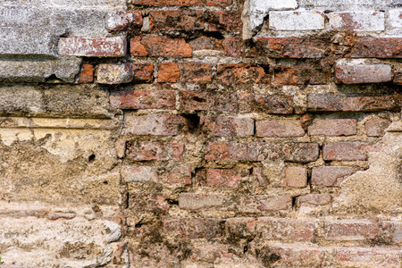 Old shabby wall cement cracks it is visible brickwork. Old Grungy Brickwork Texture.