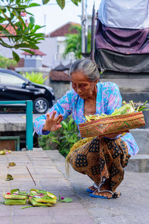 BALI, INDONESIA - SEPTEMBER 9, 2018: Balinese woman with hindu offerings to gods, Bali, Indonesia.のeditorial素材