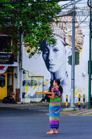 BALI, INDONESIA - SEPTEMBER 9, 2018: Balinese woman with hindu offerings to gods, Bali, Indonesia.のeditorial素材