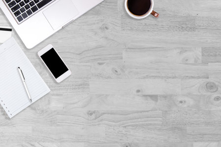 Modern white office desk table with laptop computer, smartphone, notebook and cup of coffee. Working desk table concept.Top view with copy space, flat lay.の写真素材