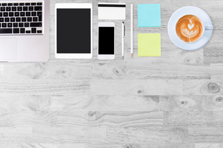 Modern white office desk table with laptop computer, smartphone, notebook and cup of coffee. Working...