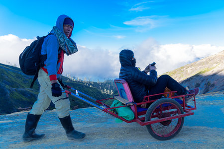 KAWAH IJEN, EAST JAVA, INDONESIA - SEPTEMBER 11, 2018 : Tourists use a service cart to visited to see view of Ijen crater lake and blue flame early morning.のeditorial素材