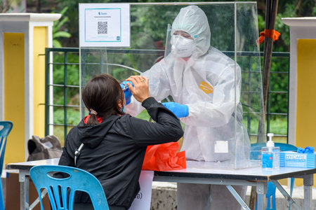 CHIANG MAI, THAILAND - JULY 24, 2021: Health workers in a protective suit conduct a COVID-19 test...