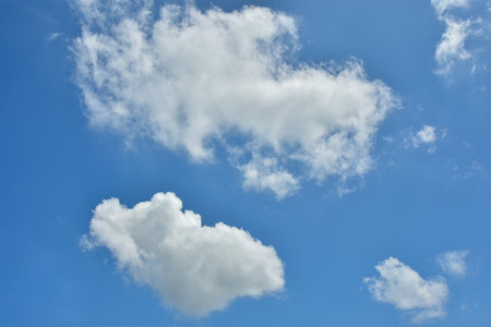 White clouds against blue sky for a backgrounds. Puffy fluffy white clouds against daytime sky. Cumulus is a fluffy cloud like a cotton ballの写真素材