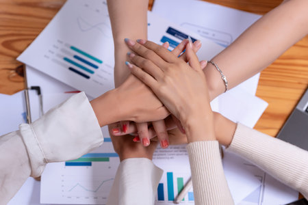 Group Asian businesses join hands for working job success after meeting in the office. Teamwork...