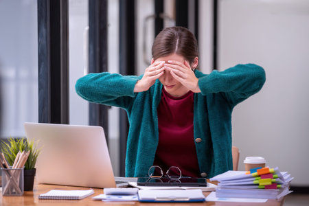 Businesswomen are stressed with work in front of a laptop and paper documents in the office....