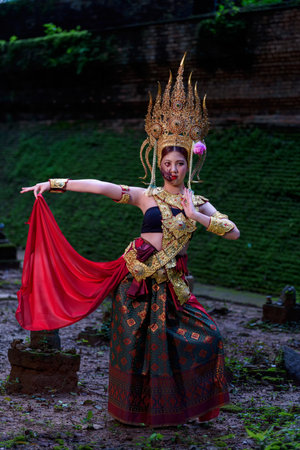 Portrait of a young Asian woman wearing an Apsara dress with ghost face makeup. Ancient ghosts in...