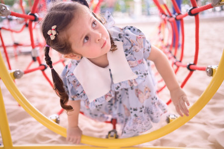 Cute girl having fun playing on playground equipment. Concept of children having fun on playground...