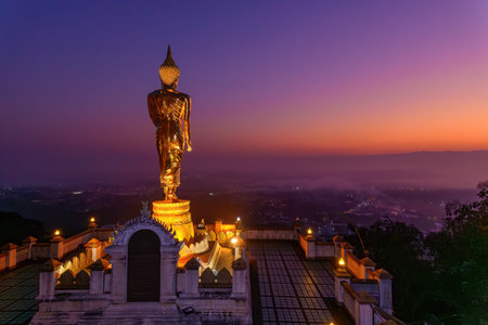 Standing Golden Buddha statue at Phra That Khao Noi Temple, Nan Province, Thailand. One of  the most...