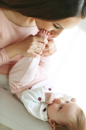 Beautiful woman with a baby is resting in a cozy house.の写真素材