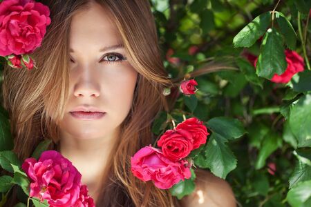 Beautiful woman portrait with roses. A young and attractive girl.の写真素材