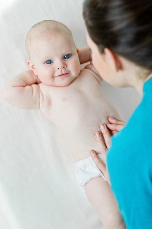 Woman with a baby on a white background. Mom holds the baby.