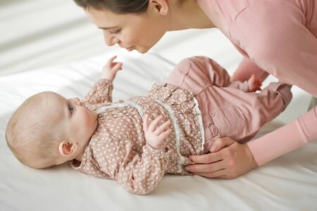 Woman with a baby on a white background. Mom holds the baby.の写真素材