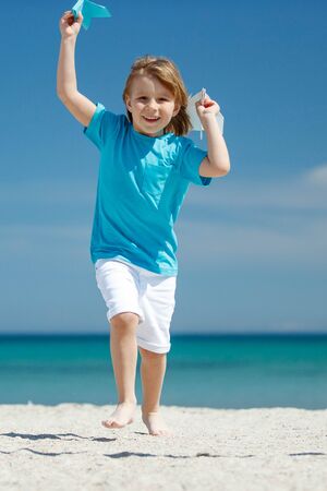 Child boy plays at sea with an airplane. Dream to travel.の写真素材