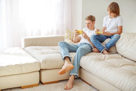Children teenagers play a game on the phone at home.の写真素材