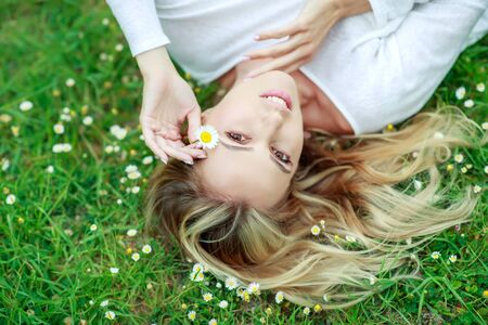 Beautiful woman with a flower. Girl with camomiles. Beautiful woman portrait.の写真素材